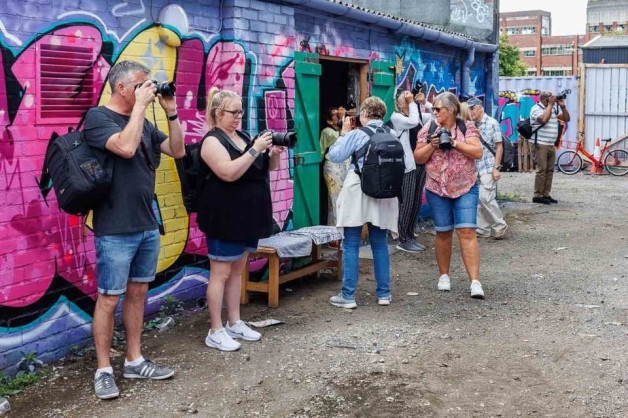 A group of camera club photographers taking pictures of graffiti in Digbeth